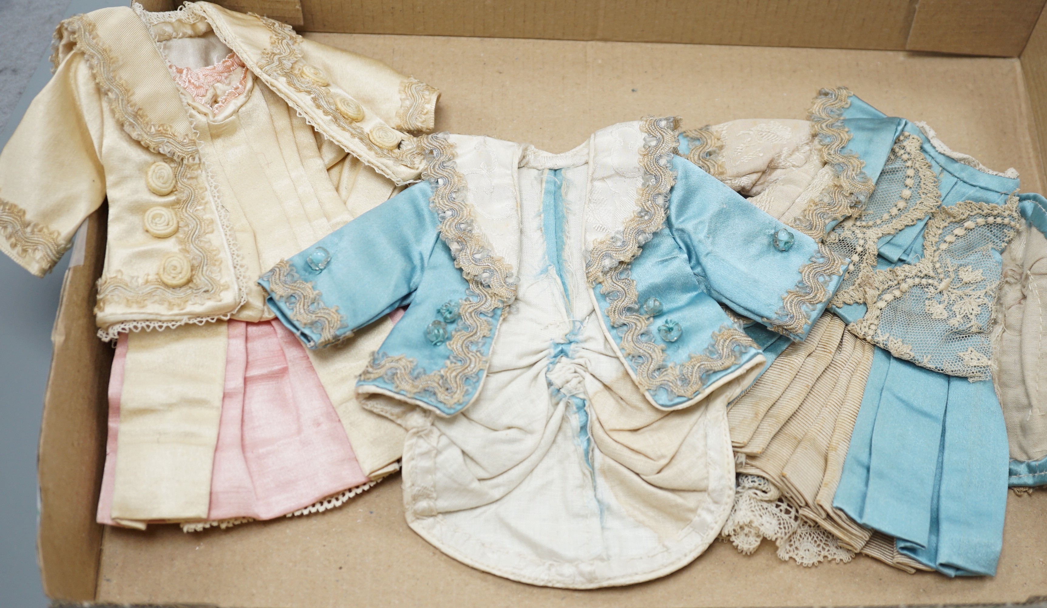 Four French style dolls dresses, average 22cm, a French silk coat and bonnet, 18cm and a small French dress and petticoat silk and lace, 12cm